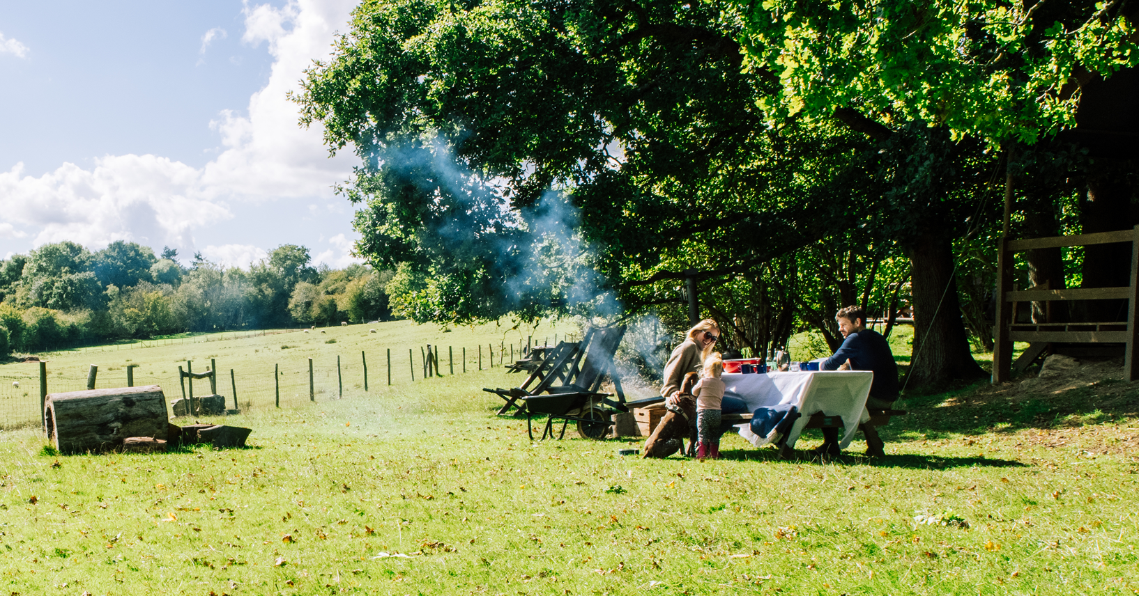 famille qui dejeune à leur terasse nature lors de leur sejour d'une semaine a la ferme
