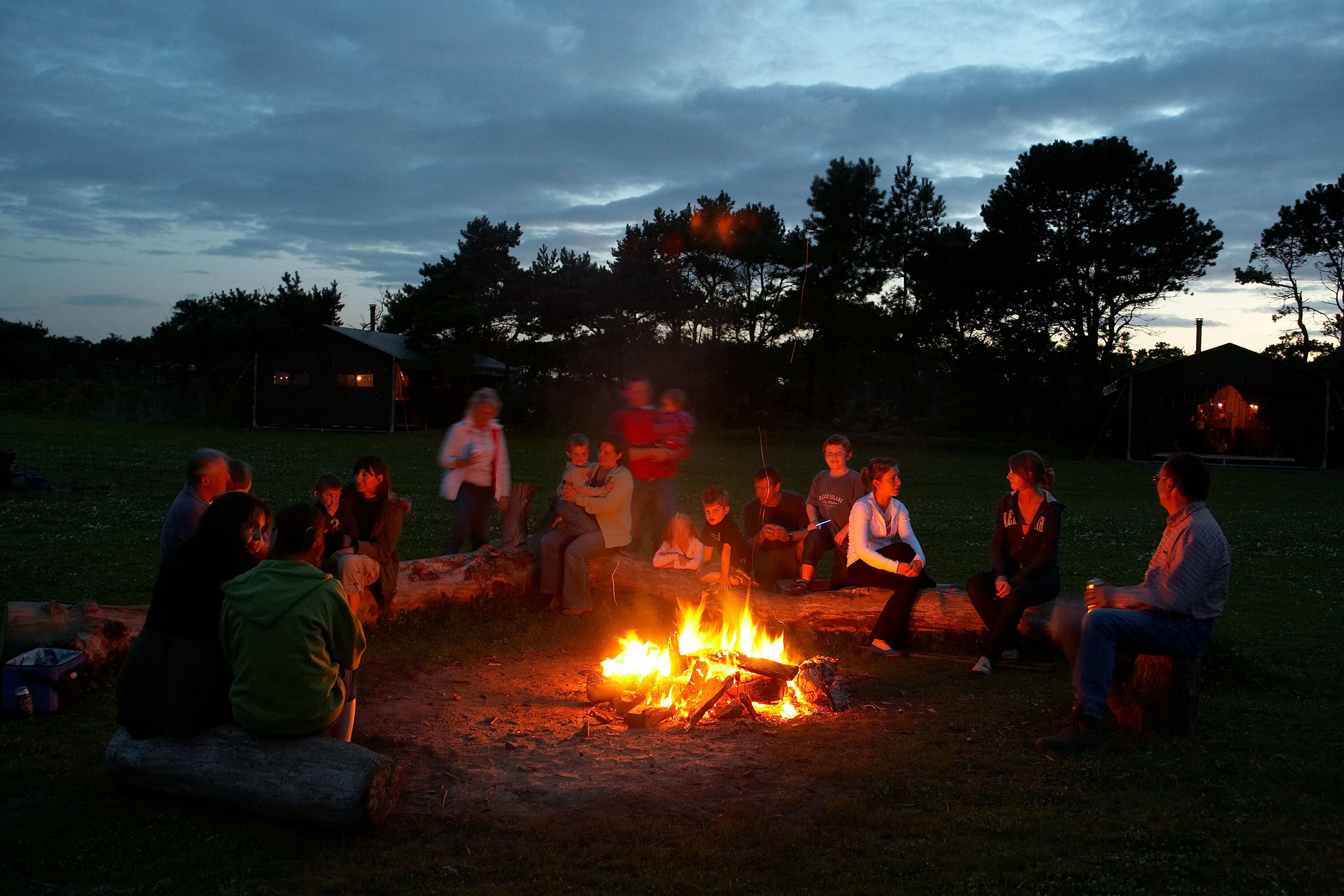 Feu de camp à la ferme avec des familles tout autour