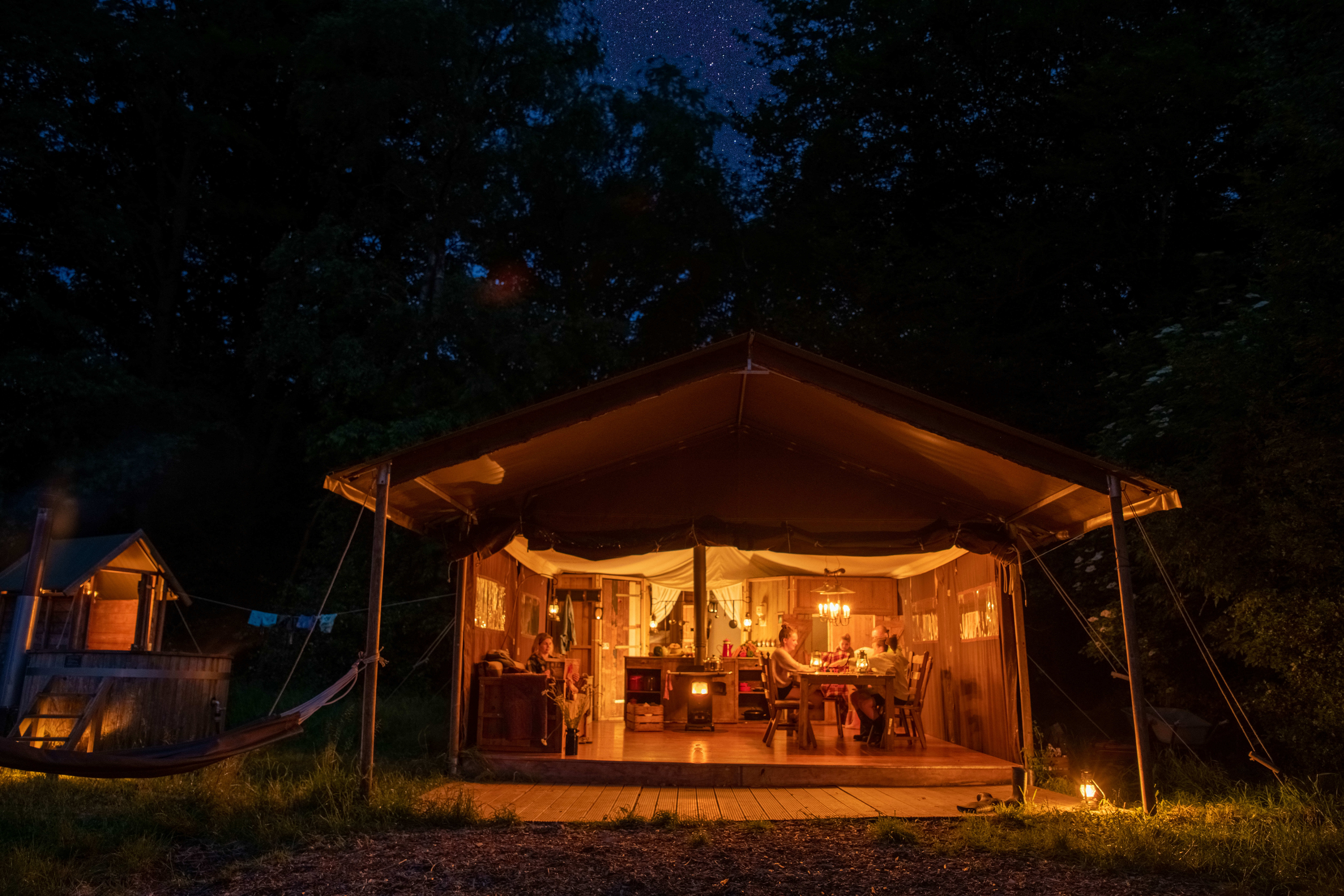 Ecolodge le soir, avec une famille à l'intérieur qui est éclairé aux bougies
