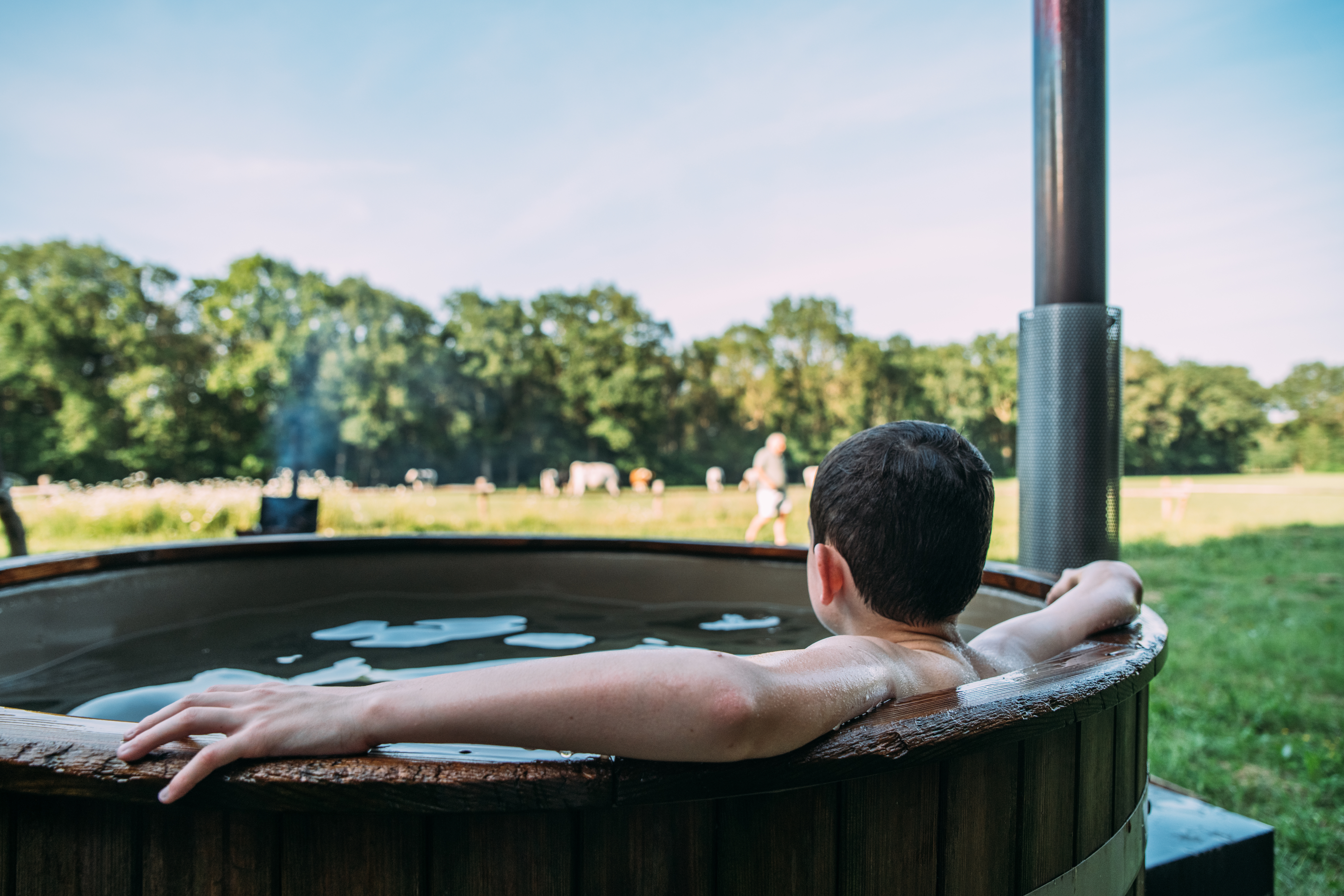 Enfant dans le bain nordique qui contemple le paysage